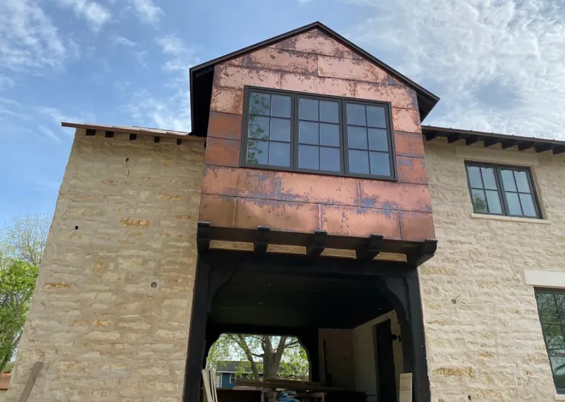 Copper metal panel facade on a stone building for Skylight Installation in Chickasaw